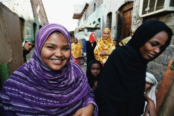 Women pictured smiling in a vendor area in Yemen