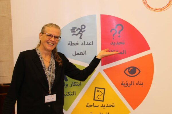 Nancy Pearson stands smiling in front of a chart at a training