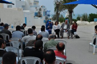 Community leaders appear seated in front of community members