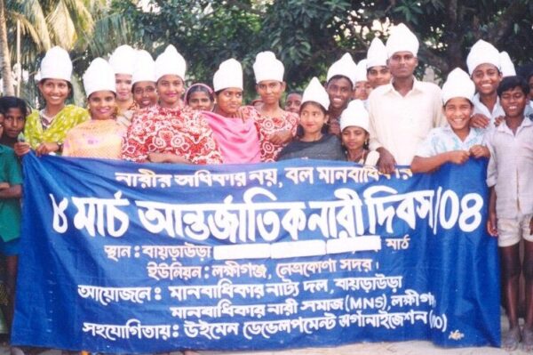 Motahar community action group holding a blue sign with white lettering