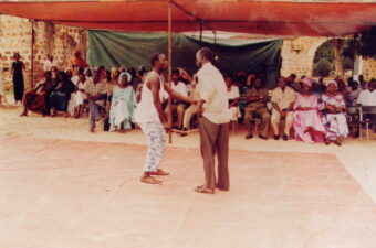 Two men acting out a story in front of an audience in Senegal