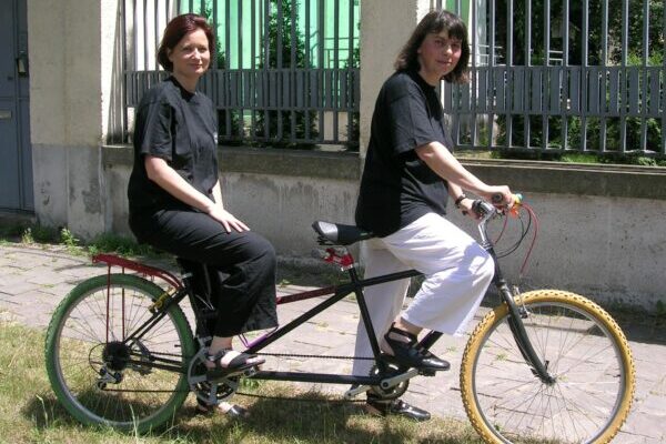 Two women on a tandem bike - one of the examples shared about engaging non-traditional allies.