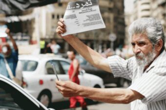 A man holds up a paper in protest