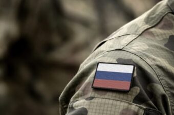 The shoulder of a Russian soldier's uniform with a flag of the Russian federation with white, blue and red stripe