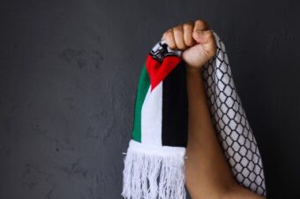 يد تحمل وشاح فلسطيني