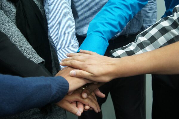 cropped image of hands coming together from a circle of people