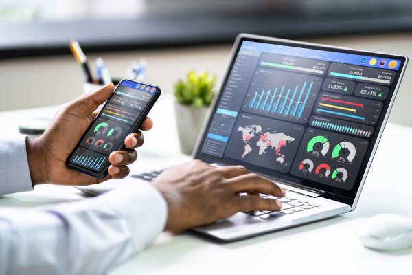 Image of charts and maps on a computer screen and phone