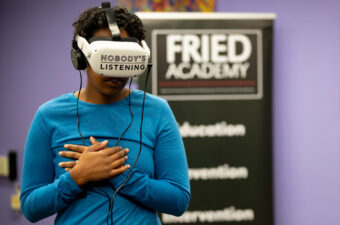 A woman wearing a virtual reality headset that says "Nobody's Listening."