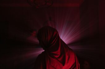 The back of a woman standing in a red hijab