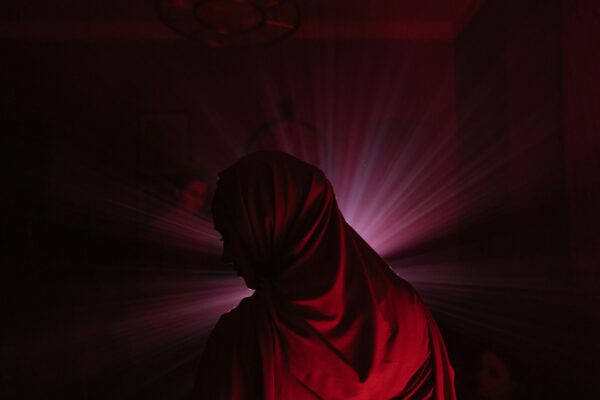 The back of a woman standing in a red hijab