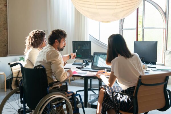 Colleagues sit around a computer looking at data