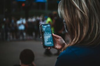 Woman looking at her phone while witnessing a protest