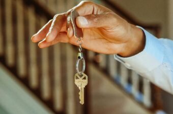 A hand outstretched holding a house key