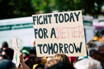 Protestors holding a sign that says Fight today for a better tomorrow