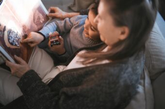 A mother and child reading an illustrated book.