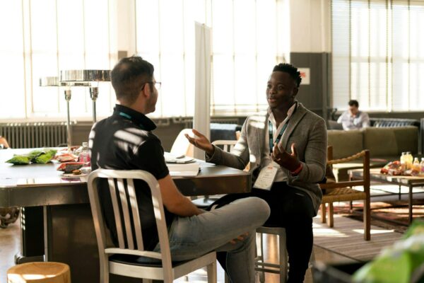 Two men sitting at a table talking