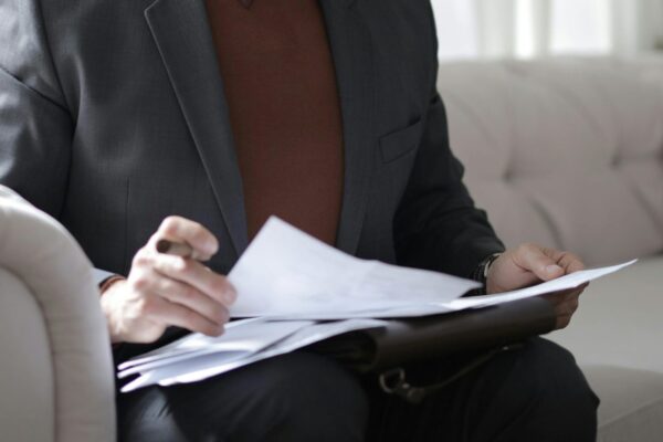 Cropped image of a man holding papers as if examining a report