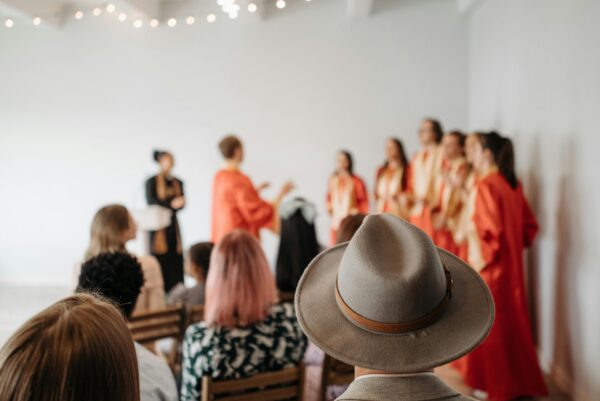 People seated in an audience watching a choir sing.