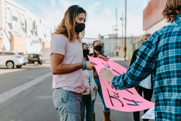 Masked protestors holding a sign about justice