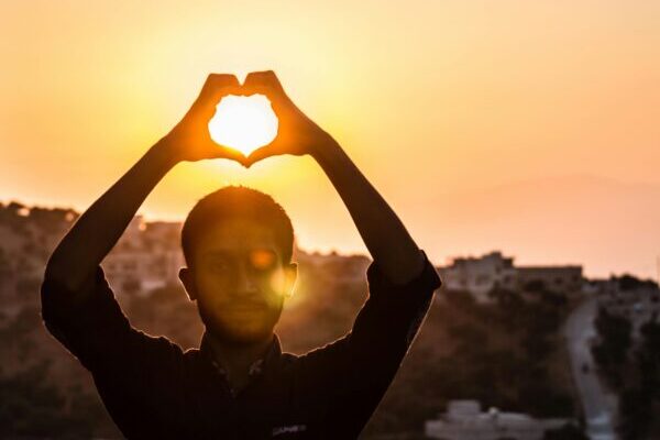 Person Making Heart Shape With His Hand During Sunset