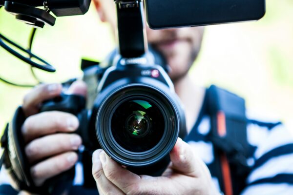 Cropped image of a videographer holding a camera