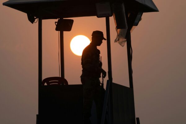 Silhouette of a military member standing in a watch tower