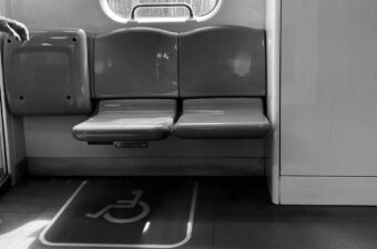 Black and white image of an accessible seat on a metro line.