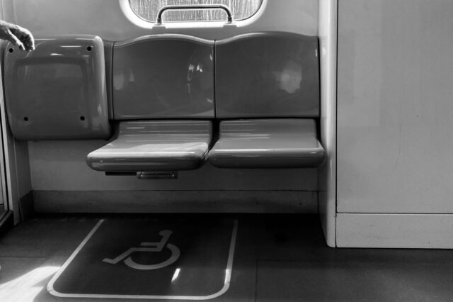 Black and white image of an accessible seat on a metro line.