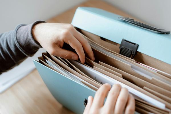 Person's hands organizing files in a folder