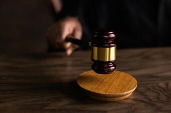 Close-up of a judge’s gavel on a wooden sound block