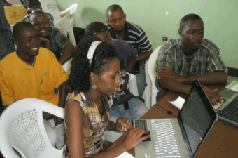 Young people in Sierra Leone gather around a computer